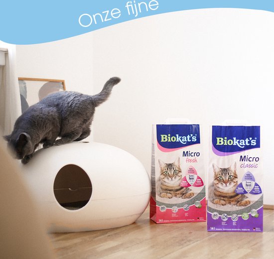Biokat's Micro Classic kattenbakvulling verpakkingen met kat op kattenbak in moderne woonkamer.