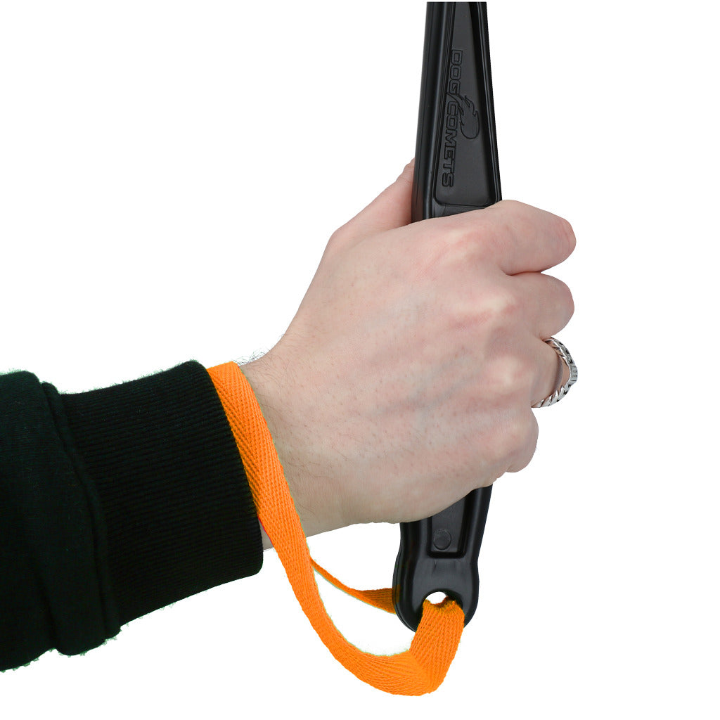 Hand die de Dog Comets Launcher Werpstok vasthoudt met een oranje handvat.